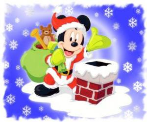 Puzle Mickey Mouse vestido como Papai Noel com um saco cheio de presentes ao lado da lareira