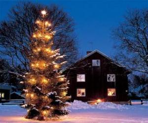 Puzle Casa com uma grande árvore de Natal decorada no jardim