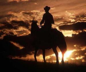 Puzle Cowboy ou vaqueiro cavalgando ao entardecer ou