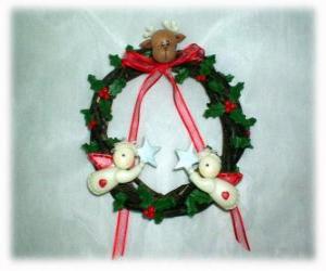 Puzle Guirlanda de Natal decorada com folhas de azevinho um chefe de uma rena, dois anjos e um laço vermelho