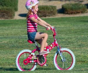 Puzle Menina andando de bicicleta no parque na primavera