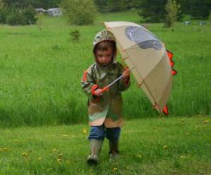 Puzle Menino com o guarda-chuva e capa de chuva sob a chuva da primavera