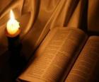 A Bíblia e uma vela acesa sobre o altar