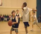 Menino, jogador de basquetebol com uma bola