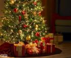 Árvore de Natal decorada com pérolas, fitas, uma grande estrela e com os presentes debaixo