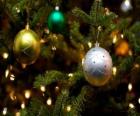 Três bolas Natal pendurados em árvore