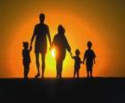 Família, pai, mãe e filhos a andar no tre crepúsculo