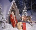 Papai Noel na porta de sua casa com uma rena e os presentes