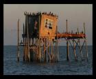 Palafita com cabana de pescadores, a construção apoiado sobre pilares em lago