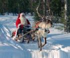 Papai Noel em seu trenó com renas na neve