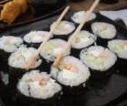 Comida japonesa com os pauzinhos, é conhecido como maki pois é sushi enrolado com algas