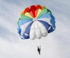 Paraquedista descendo através das nuvens em um pára-quedas depois de saltar de um avião