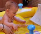 Garota no banho numa pequena piscina inflável