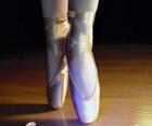 Os pés de uma bailarina com as sapatilhas de ballet
