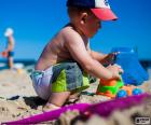 Uma criança brincando com um caminhão na praia