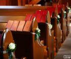 Os bancos de igreja, adornados com flores para um casamento