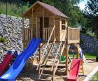 Estrutura de madeira de um playground, onde as crianças podem brincar com uma pequena casa e escorregador