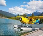 Hidroavião biplano amarelo nas águas de um lago