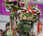 Um homem disfarçado como um planta, pintada de verde para comemorar o Carnaval