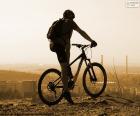 Ciclista com sua bicicleta de montanha, observando a paisagem durante uma excursão