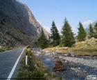 Rio no vale ao longo de uma estrada de montanha estreita