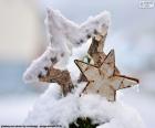 Duas estrelas Natal de madeira parcialmente coberto por neve