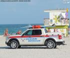 Veículo de resgate de mar na praia de Miami Beach, com uma prancha de surf no telhado