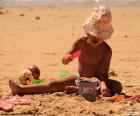 Uma rapariga no verão brincando com a areia da praia