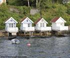 Quatro pequenas casas construídas no lago na Noruega