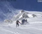 Cinco alpinistas subindo no meio de uma tempestade de vento