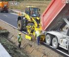 Dos trabalhadores que trabalham em uma rodovia