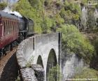 Um trem de vapor que passa através de um viaduto de pedra antigo