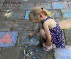 Menina brincando de desenhar com giz no chão